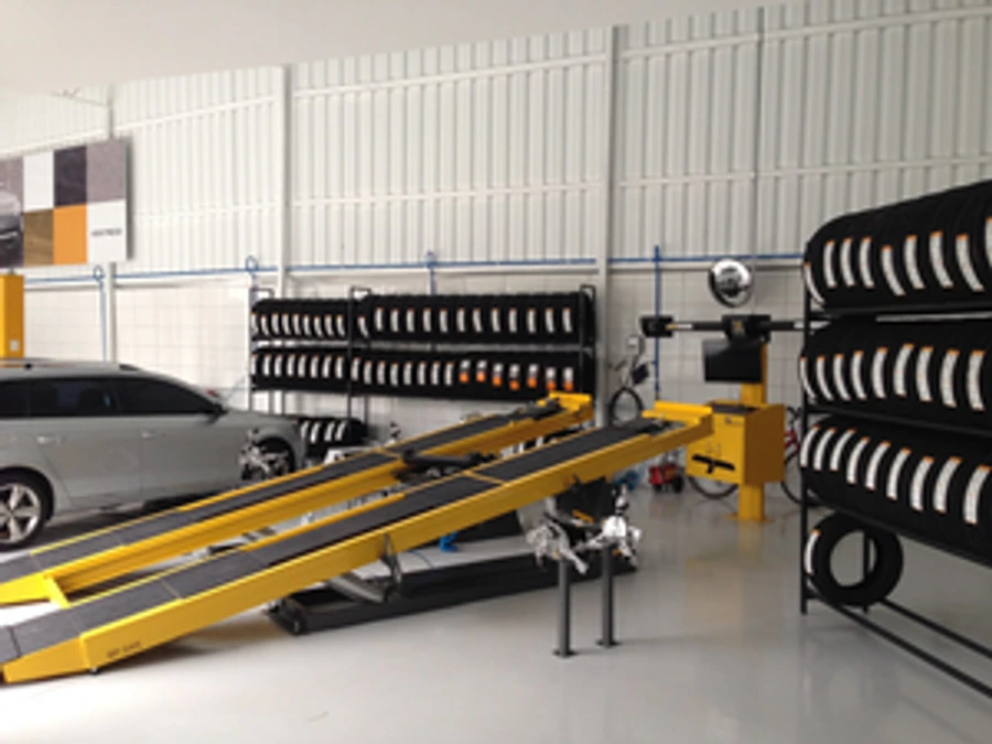 Interior da oficina AGIS Car Service com rampa de alinhamento